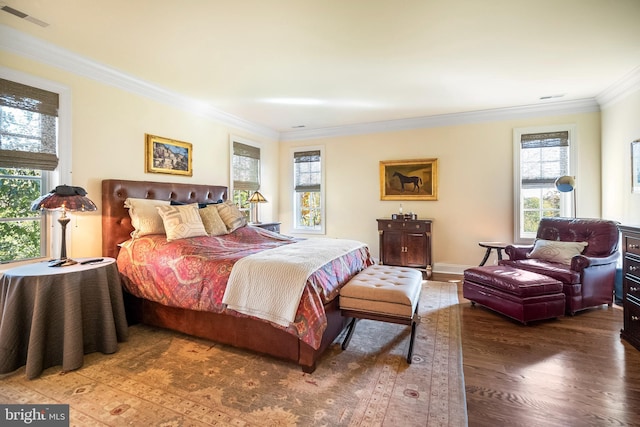 bedroom featuring hardwood / wood-style flooring, ornamental molding, and multiple windows