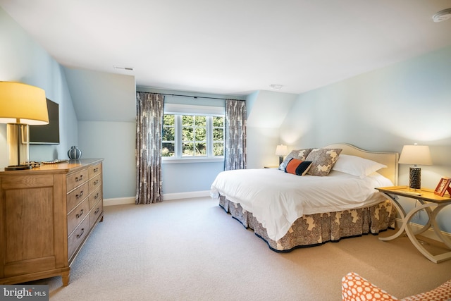 bedroom featuring lofted ceiling and light colored carpet