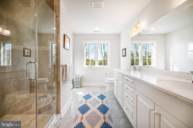 bathroom with vanity, toilet, tile patterned floors, and a shower with door