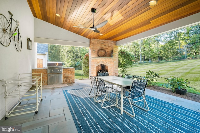 view of patio / terrace with area for grilling, an outdoor brick fireplace, and a grill