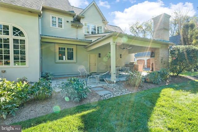 rear view of house featuring a yard and a patio