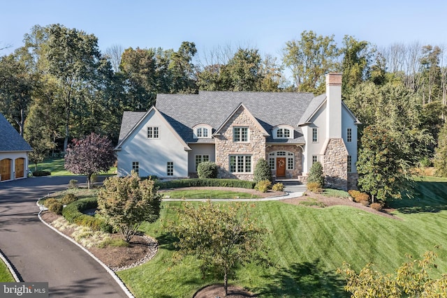 french provincial home featuring a front yard