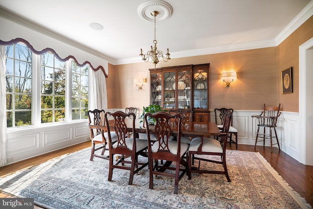 dining room with crown molding, a notable chandelier, and hardwood / wood-style flooring