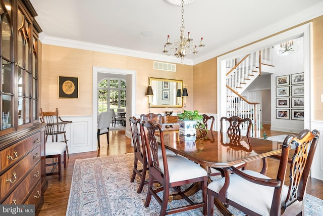 dining room with crown molding, a chandelier, and dark wood-type flooring