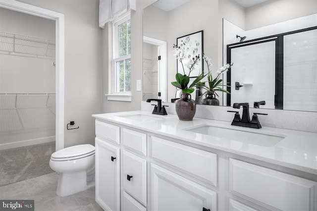 bathroom featuring vanity, toilet, and a shower with door