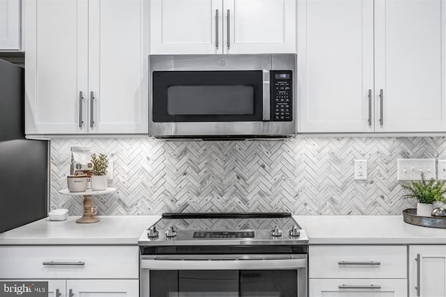 kitchen with appliances with stainless steel finishes, white cabinetry, and tasteful backsplash