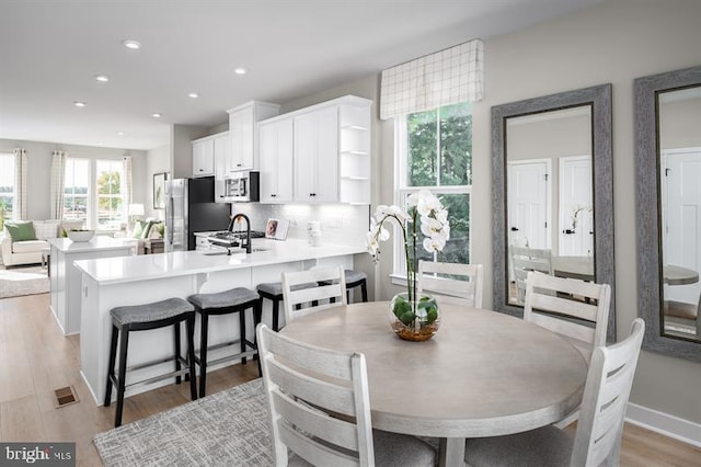 dining area featuring sink and light wood-type flooring