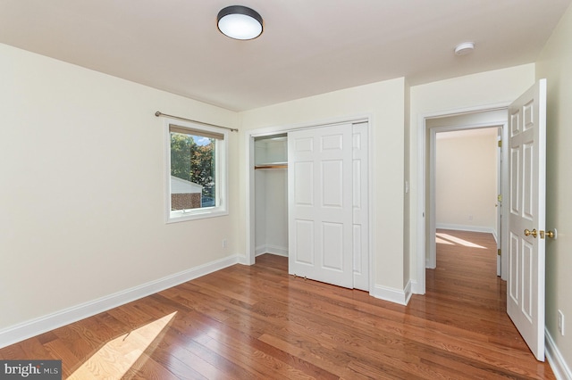 unfurnished bedroom featuring a closet and wood-type flooring