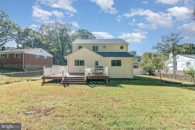 rear view of property with a wooden deck and a lawn