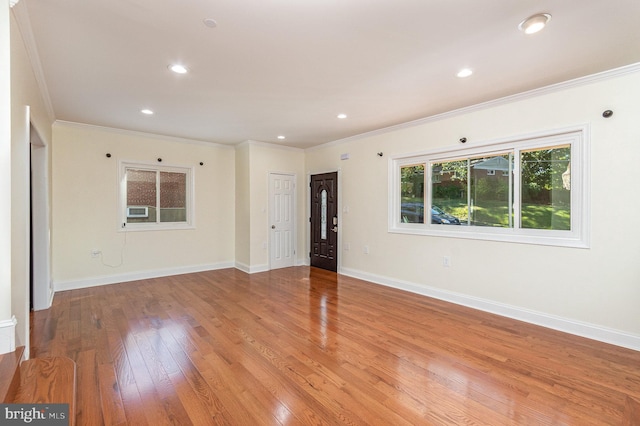 spare room featuring crown molding and light wood-type flooring