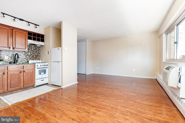 kitchen featuring tasteful backsplash, an AC wall unit, light hardwood / wood-style floors, sink, and white appliances