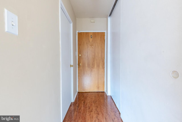 hallway with wood-type flooring and a textured ceiling