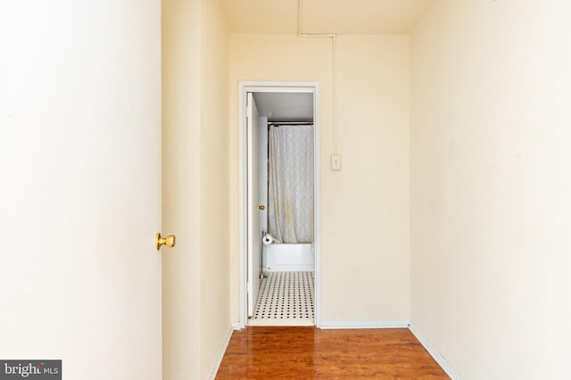 hallway with hardwood / wood-style flooring