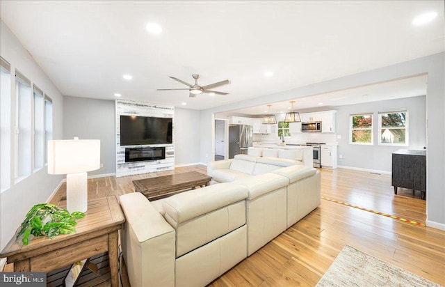 living room featuring light hardwood / wood-style flooring and ceiling fan