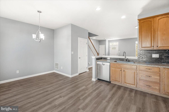 kitchen with decorative backsplash, stainless steel dishwasher, sink, an inviting chandelier, and hanging light fixtures