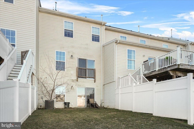 back of property with cooling unit and a lawn