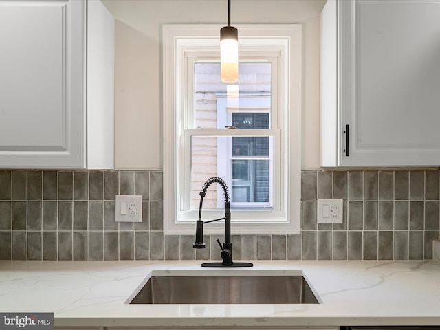 714 W Stephen St, Martinsburg, WV 25401 - kitchen featuring light stone counters, pendant lighting, white cabinetry, tasteful backsplash, and a sink