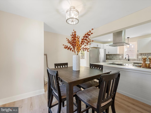714 W Stephen St, Martinsburg, WV 25401 - dining area with light wood finished floors, a notable chandelier, and baseboards