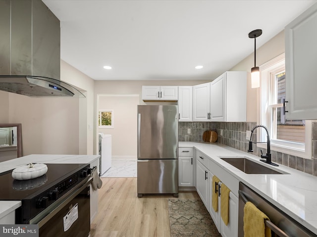 714 W Stephen St, Martinsburg, WV 25401 - kitchen featuring a sink, stainless steel appliances, wall chimney exhaust hood, decorative light fixtures, and white cabinets