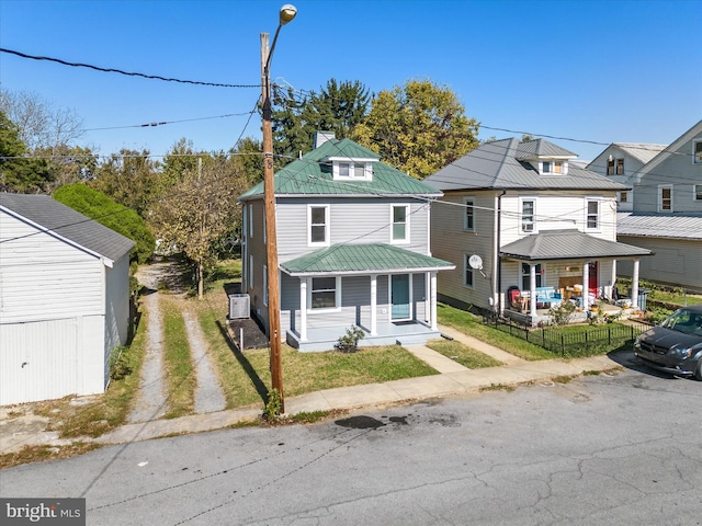 714 W Stephen St, Martinsburg, WV 25401 - view of front of house with covered porch, fence, a front lawn, and metal roof