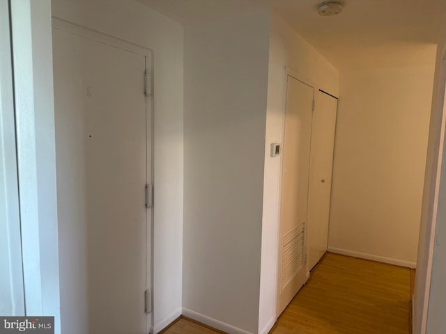 corridor with light hardwood / wood-style floors