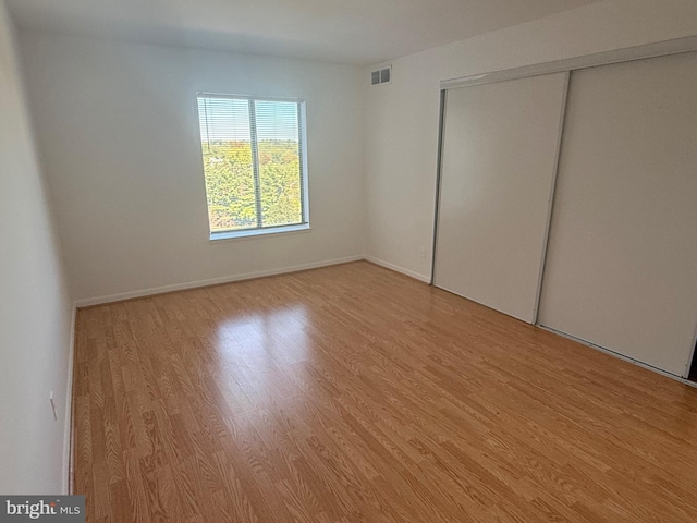 unfurnished bedroom featuring a closet and light wood-type flooring