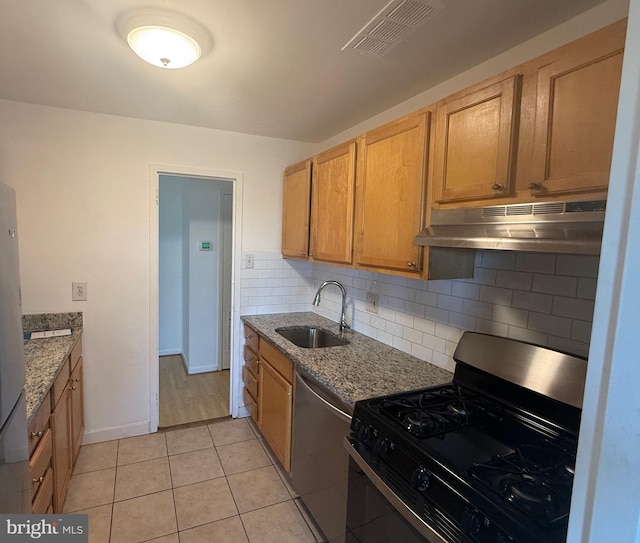 kitchen with light stone countertops, sink, stainless steel dishwasher, black range with gas cooktop, and light tile patterned floors