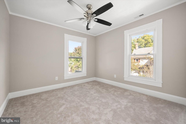 carpeted empty room featuring crown molding, plenty of natural light, and ceiling fan