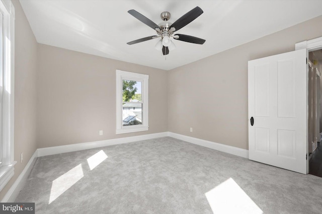 spare room featuring light colored carpet and ceiling fan