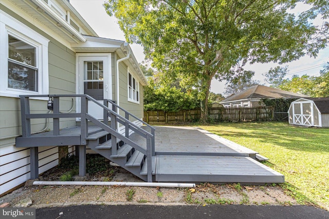 deck with a storage shed and a yard