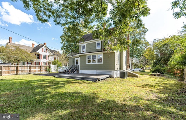 back of house featuring a wooden deck and a lawn