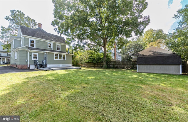 back of property featuring a shed and a yard