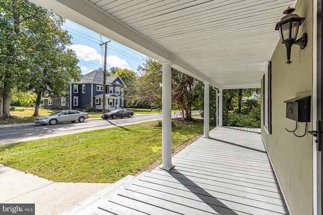 deck featuring covered porch and a lawn