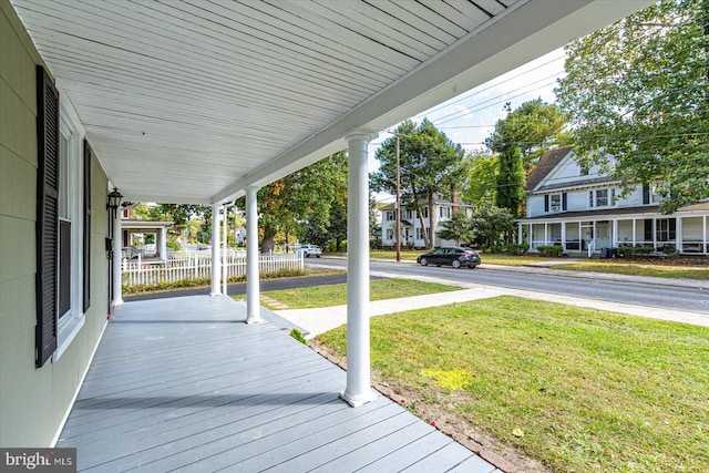 wooden deck with a yard and covered porch