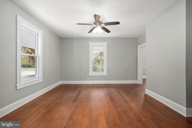 spare room with dark wood-type flooring and ceiling fan