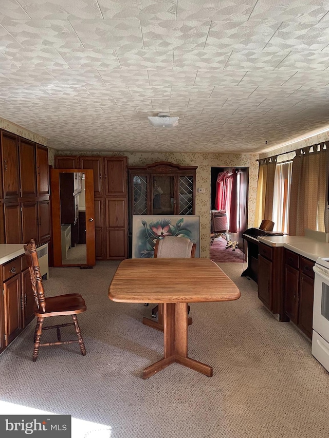 unfurnished dining area featuring a textured ceiling, cooling unit, light colored carpet, and radiator