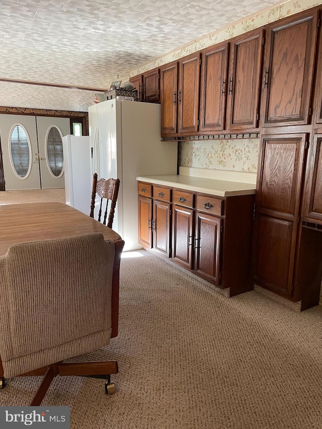 kitchen with white fridge, a textured ceiling, and light colored carpet