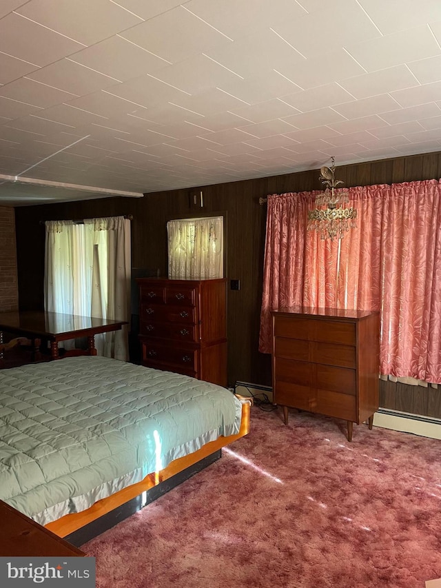 unfurnished bedroom with a baseboard radiator, carpet floors, wooden walls, and an inviting chandelier