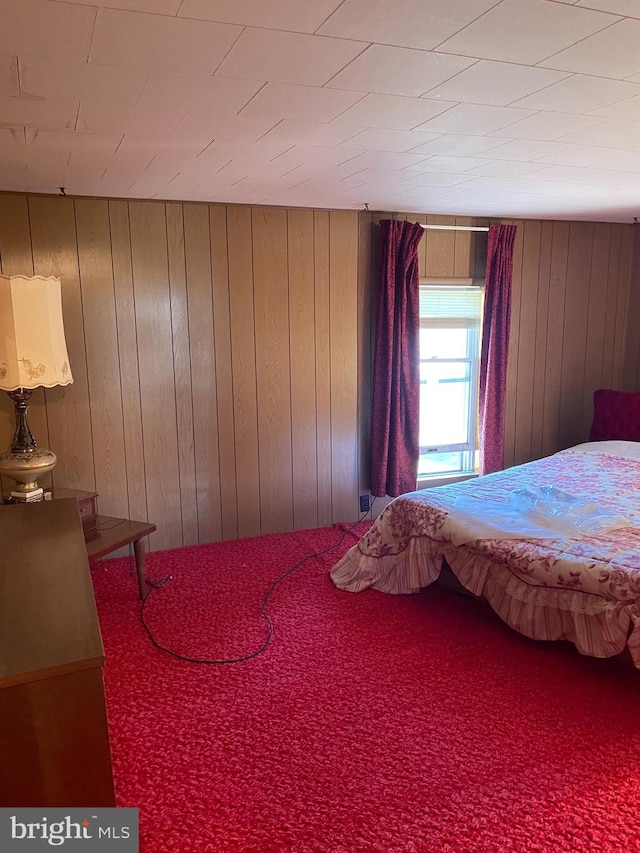 carpeted bedroom with wood walls