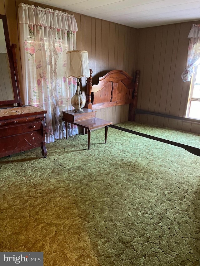 bedroom with carpet floors and wooden walls