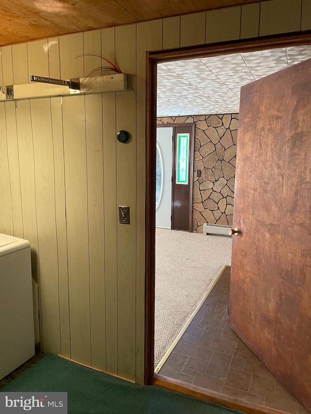 interior space featuring wooden walls, a baseboard heating unit, and wooden ceiling