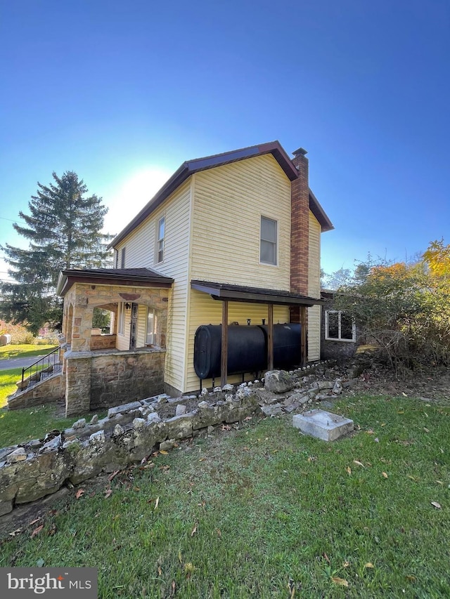 20403 Morgan St SW, Midlothian, MD 21543 - view of side of property with a yard, heating fuel, stone siding, and a chimney