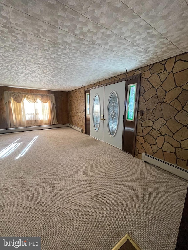 entrance foyer featuring a baseboard radiator, a textured ceiling, carpet floors, and french doors