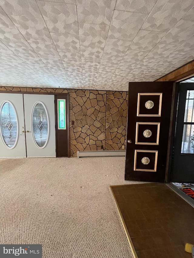 foyer with carpet and a baseboard heating unit