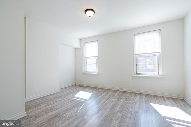 spare room with a wealth of natural light and light hardwood / wood-style floors