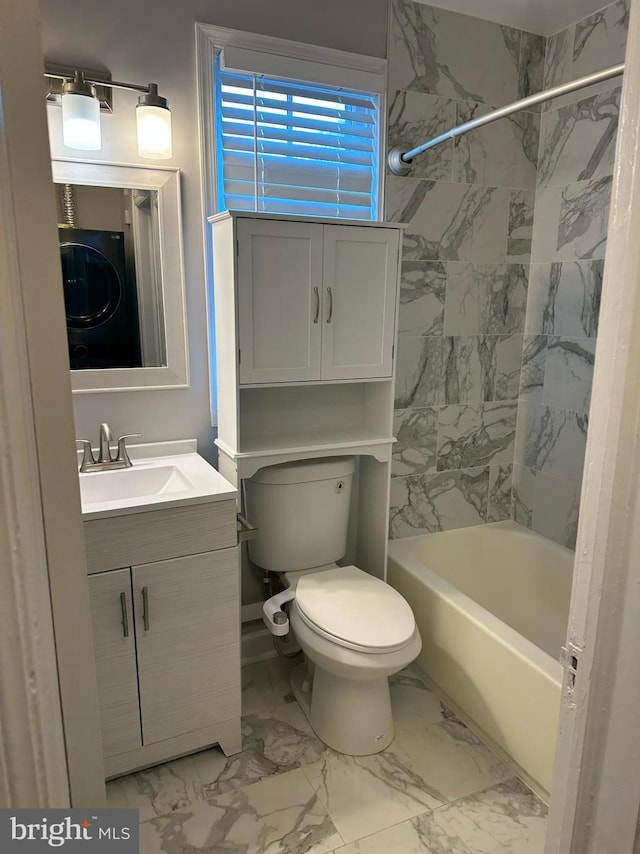 full bathroom with vanity, toilet, stacked washer and clothes dryer, and tiled shower / bath