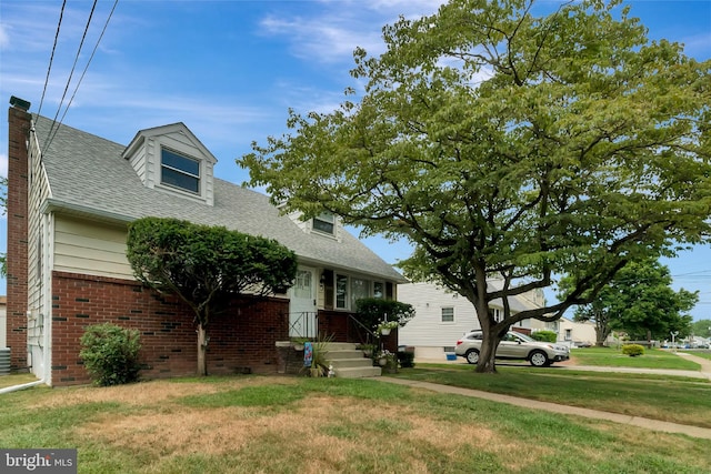 cape cod-style house with a front yard