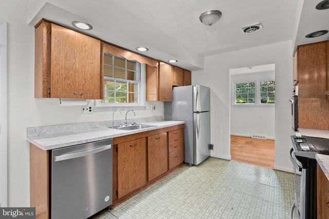 kitchen with light hardwood / wood-style floors, stainless steel appliances, and sink