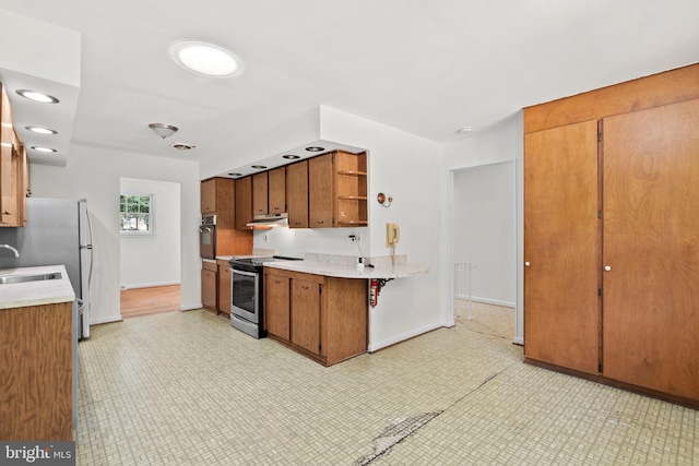 kitchen featuring kitchen peninsula, stainless steel appliances, and sink