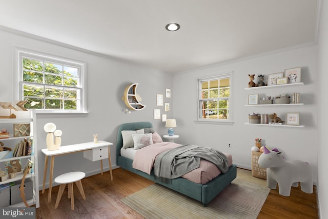 bedroom featuring crown molding, multiple windows, and hardwood / wood-style floors